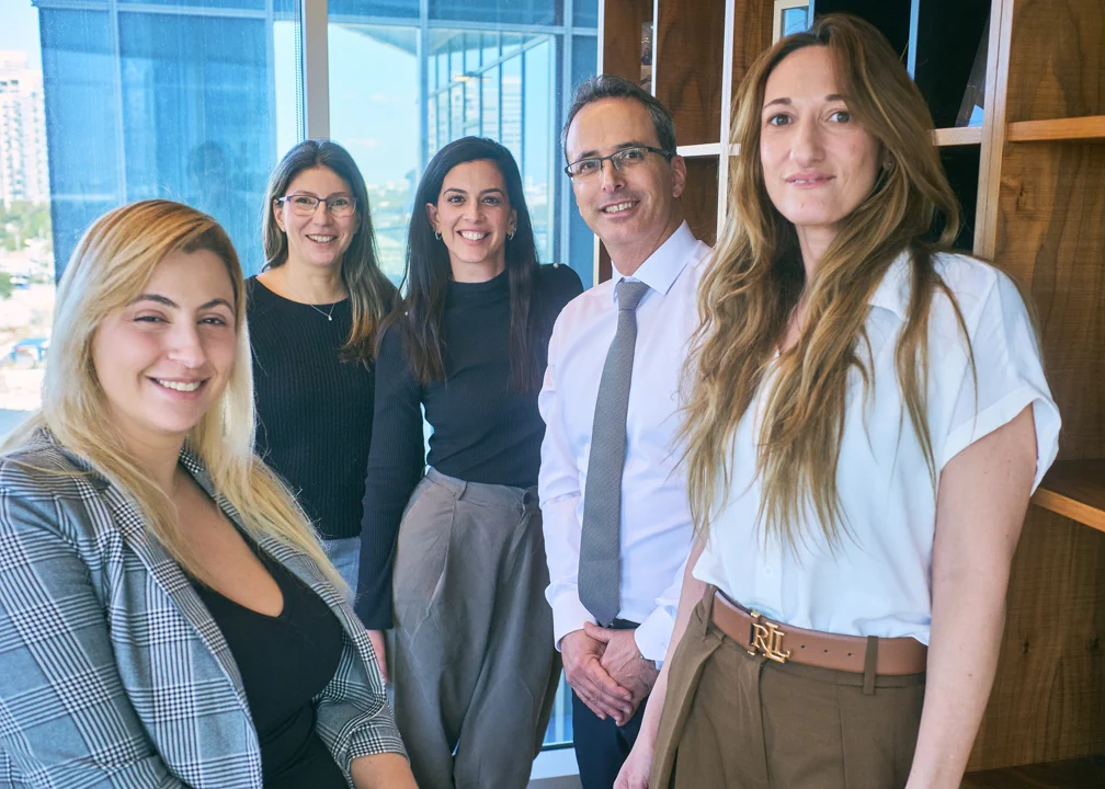 צילום צוות ארגוני של חמישה עובדים מחייכים במשרד — צילום תדמית קבוצתי באולפן החדר הירוק תל אביב