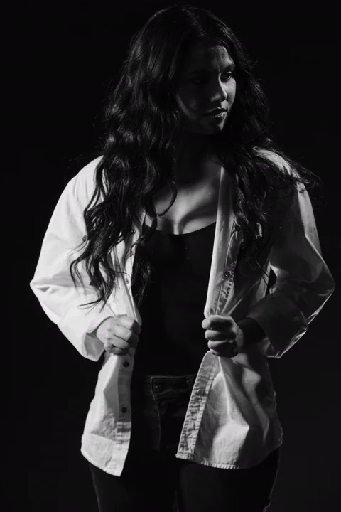 פורטרט דרמטי בשחור-לבן בתאורת לואו-קי של אישה בחולצה לבנה — צילום סטילס, החדר הירוק